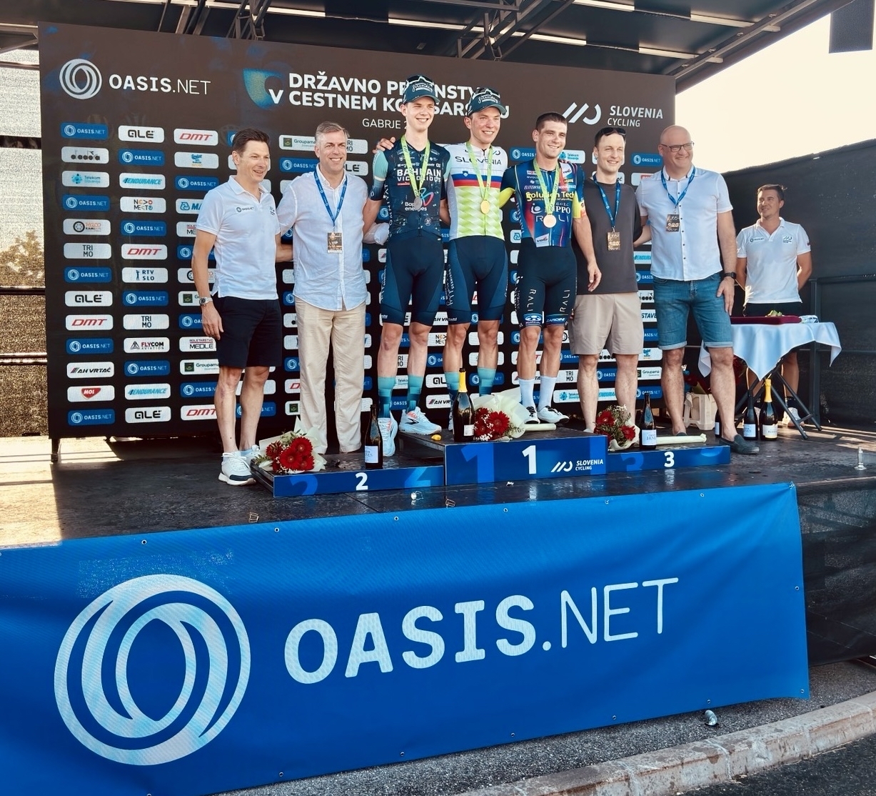 The new national champions on the podium in Gabrje with medals and the Oasis banner below the stage